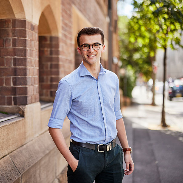 Postgraduate Notre Dame male student wearing a blue shirt standing in front of the Sydney campus 