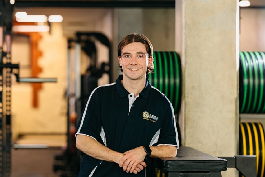 Notre Dame undergraduate male Physiotherapy student wearing a polo standing in the gym on the Fremantle campus