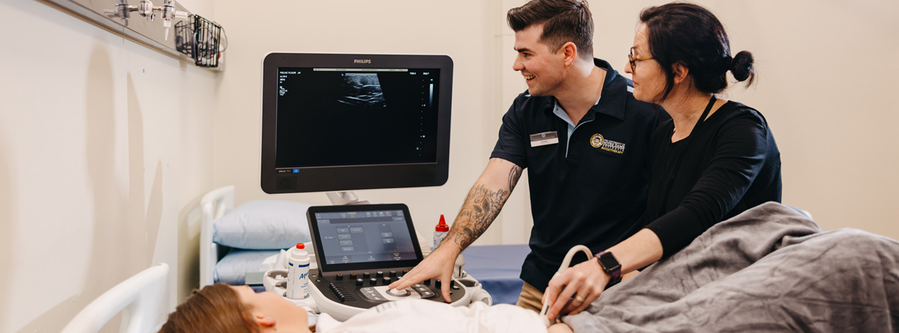 Bachelor of nursing midwifery student helping to facilitate in an ultrasound check up 