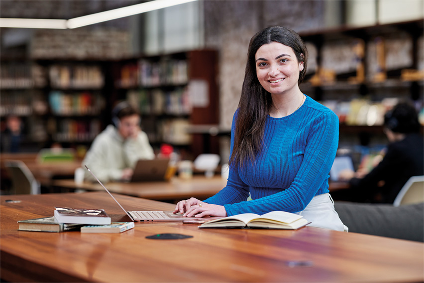 Notre Dame female philosophy and theology undergraduate student wearing a blue top sitting in the Sydney campus library