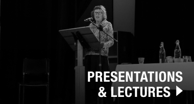 Speaker Elaine Rabbit on stage with presentations and lectures in white writing over the top