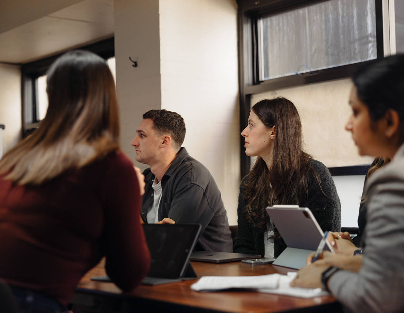 A classroom of students looking to the left focusing on the lecturer.