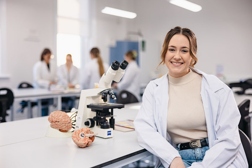 Notre Dame female undergraduate science student wearing a lab coat in the science lab located on the Fremantle campus 