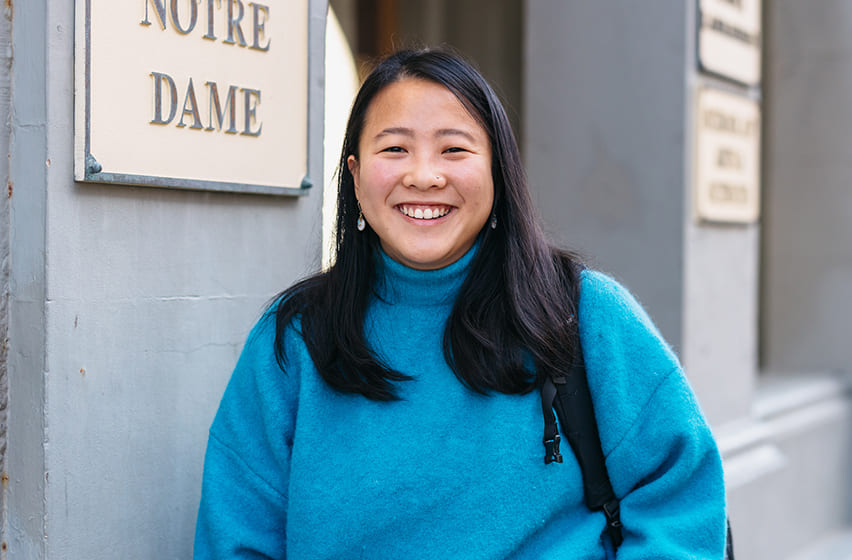 Arts and Sciences student Felicia wearing a blue jumper standing in front of the Arts & Science building on the Fremantle Campus.