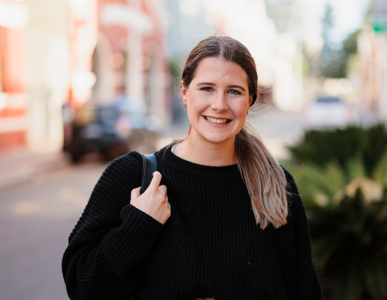 Female Fremantle student wearing a black sweater smiling for the camera 