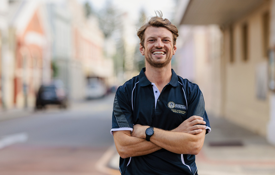 Notre Dame undergraduate male education student wearing a black polo shirt standing in a street near the Fremantle campus