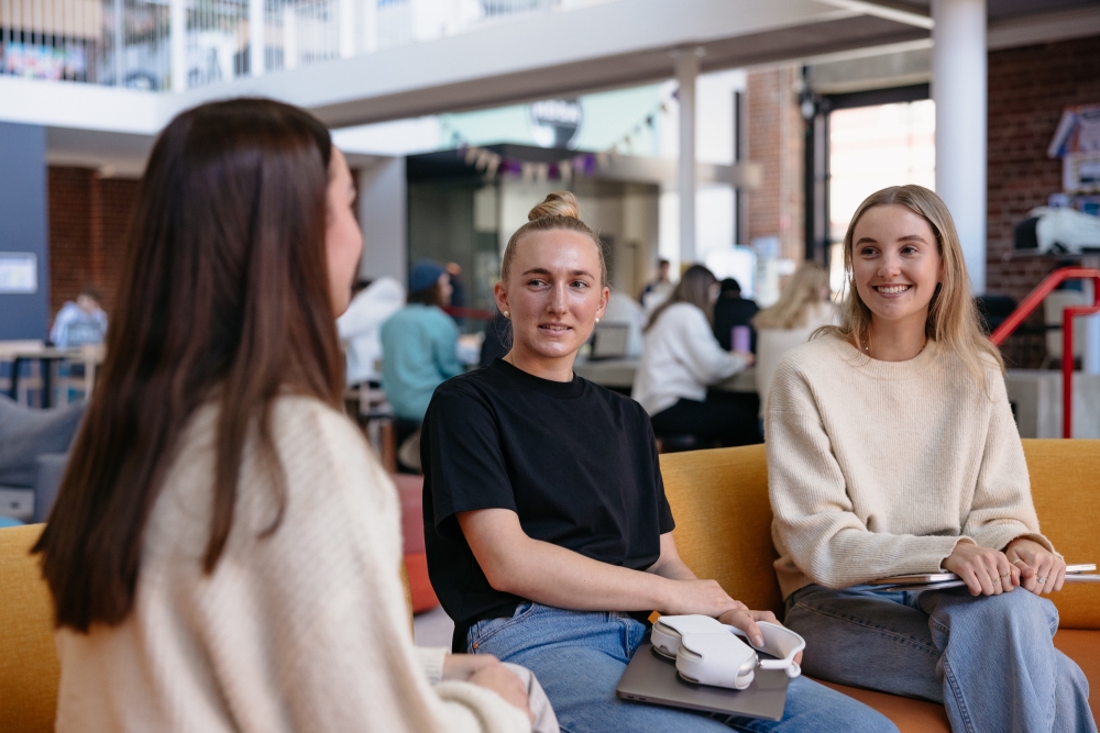 three-students-chatting-in-prindiville-hall