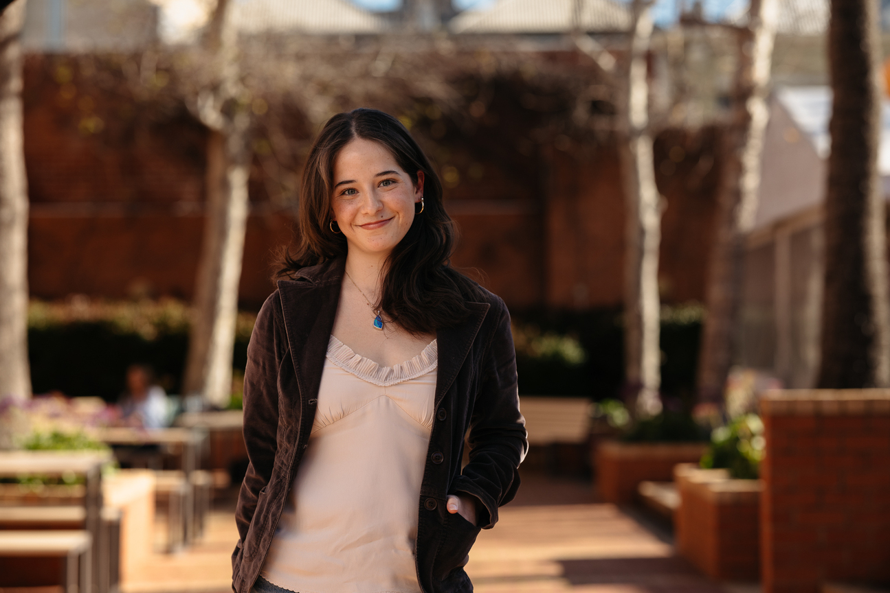 Female Fremantle student standing smiling in front of the Round House in Fremantle