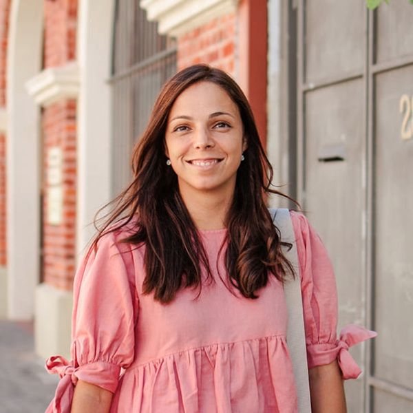 Female student in a pink shirt smiling outside of a building on the Fremantle campus 