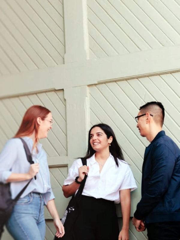 Group of 3 Notre Dame students talking outside of campus 