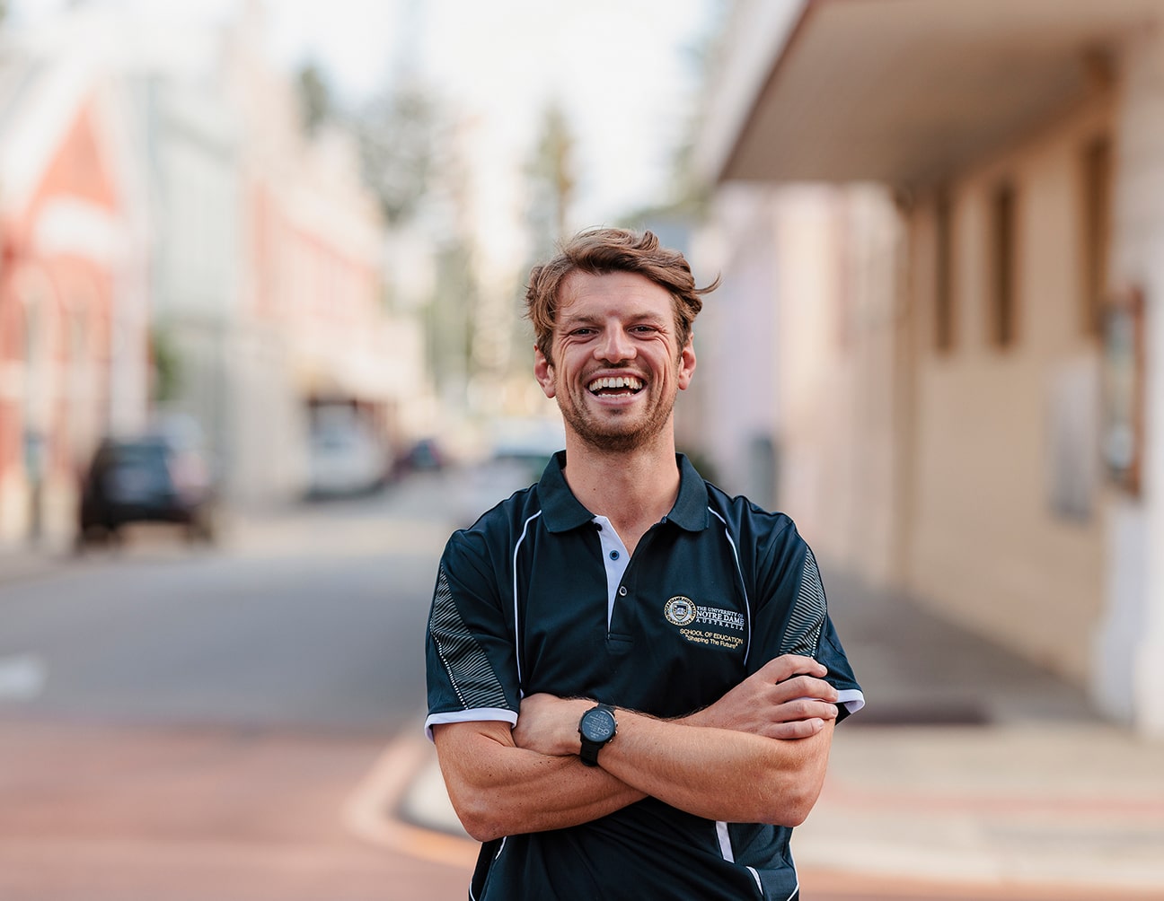 Education student Calum Ware in a Notre Dame polo shirt smiling outside on the Fremantle campus 
